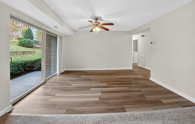 A room with wooden flooring and a ceiling fan.