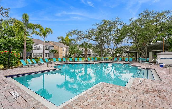 Community Swimming Pool with Pool Furniture at Huntington Place Apartments located in Sarasota, FL.