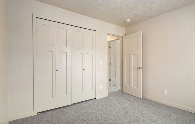 a large bedroom with closet doors at Old Farm Apartments, Elkhart, Indiana