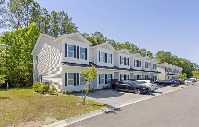 a row of houses with cars parked in front of them