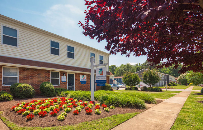 A building with a sign in front of it and a flower bed in the front.