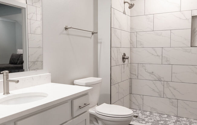 a bathroom with a shower and a sink and a toilet