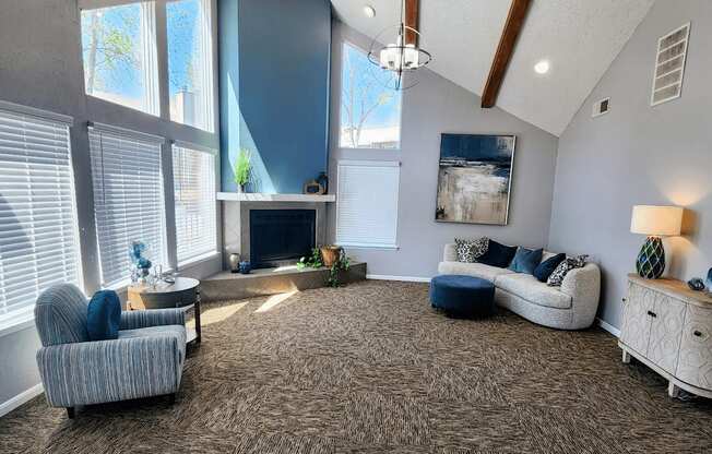 Clubhouse living room at Skyler Ridge with grey carpeting, sofa seating, and coffee tables.