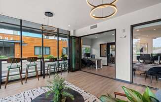 A modern living room with a bar area and a view of the street outside.
