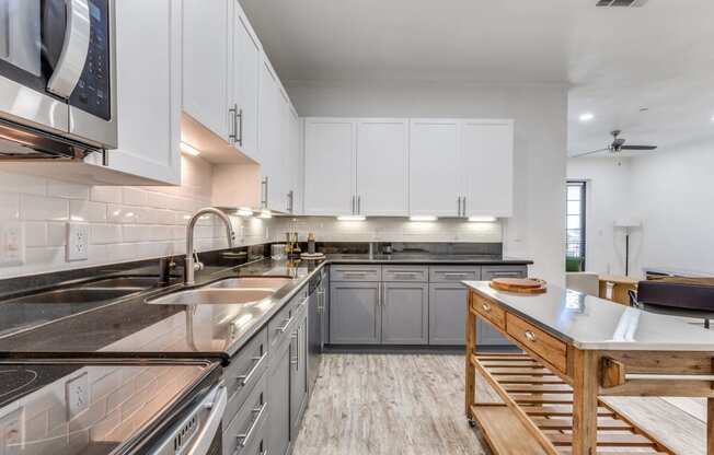 a large kitchen with stainless steel counter tops and white cabinets