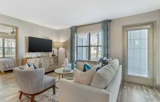 A living room with a grey couch, a chair, and a television.
