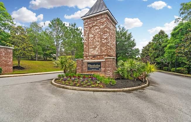 the roundabout in front of a brick tower with a sign on it