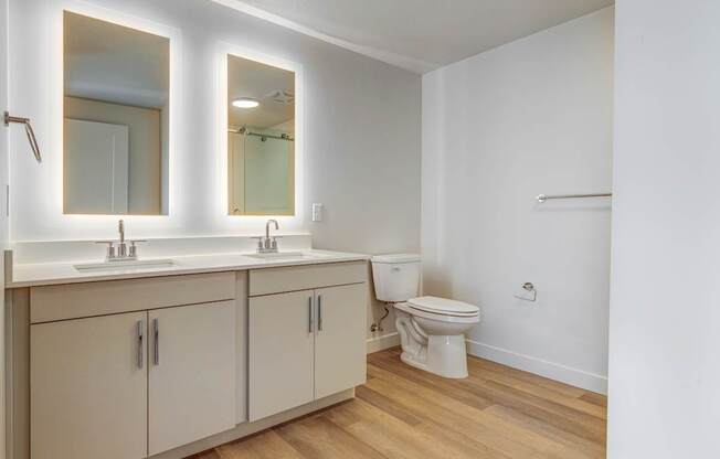 A bathroom with a toilet, sink, and mirror.