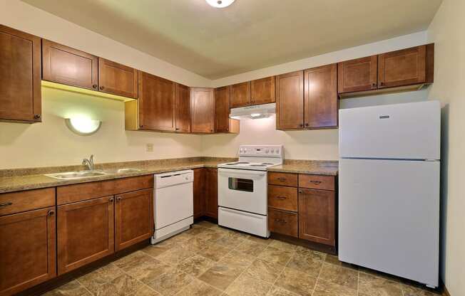 a kitchen with white appliances and wooden cabinets. Fargo, ND Spring Apartments