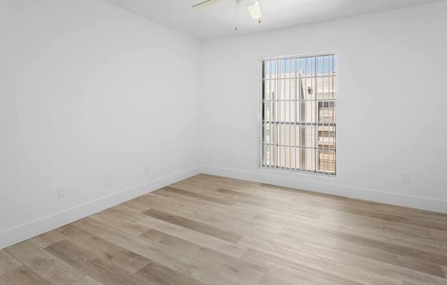 A room with a window and wooden flooring.