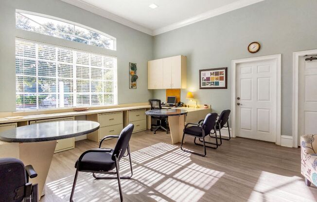 Leasing office with large window, desks, chairs, and painted walls