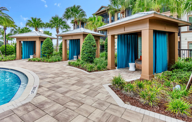 a home with a paver driveway and a pool