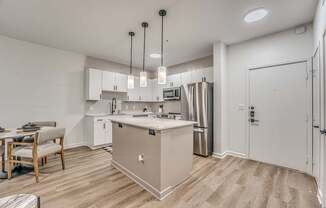 A kitchen with a white island and stainless steel appliances.