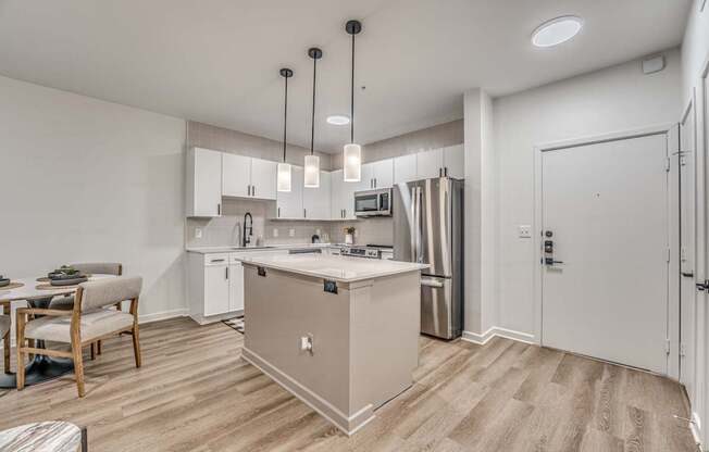 A kitchen with a white island and stainless steel appliances.