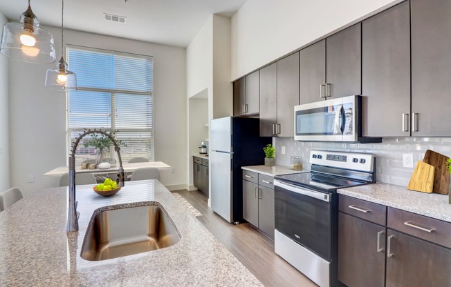 an open kitchen with stainless steel appliances and granite counter tops