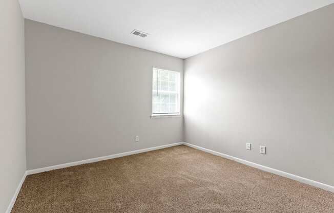 an empty room with carpet and a window