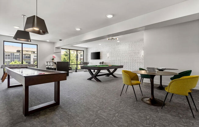 A room with a pool table, ping pong table, and a TV.