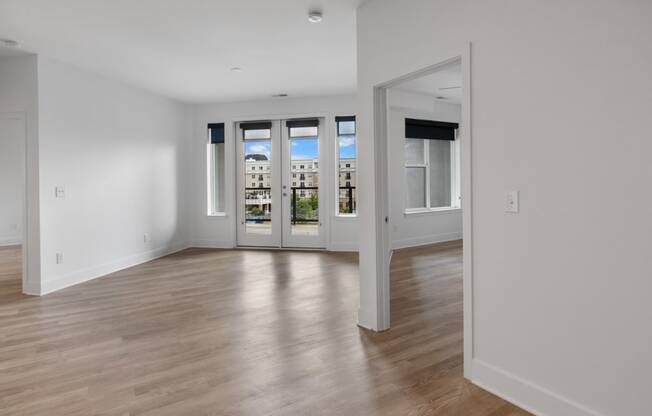 a living room with white walls and a door to a balcony