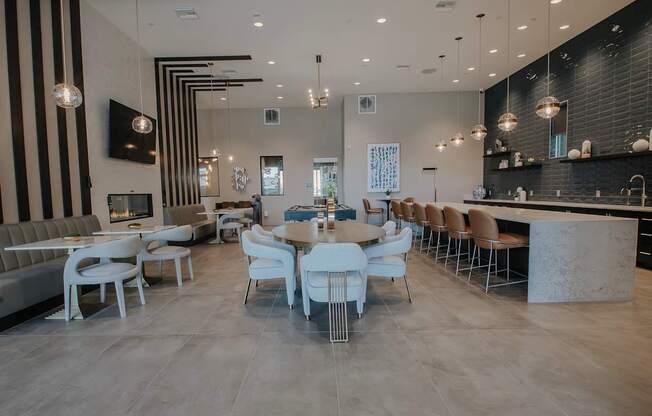 A large modern clubhouse with dining area, long bar, cafe seating, and pool table.