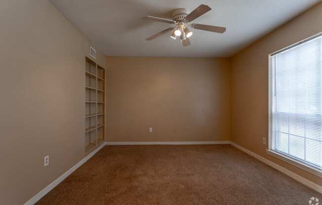 a living room with a ceiling fan and a window