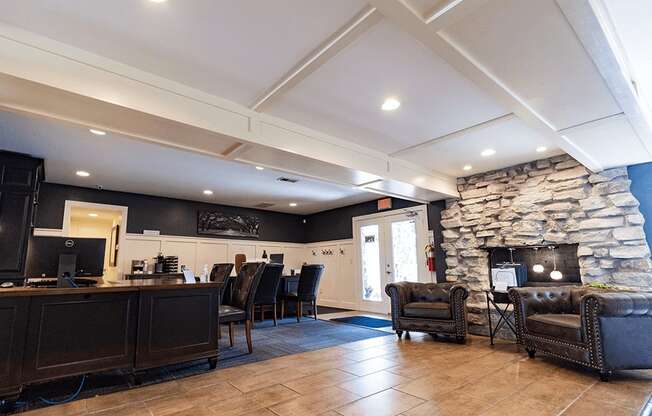 a lobby with a stone fireplace and a desk with chairs