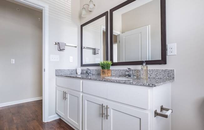 a bathroom with a vanity with two mirrors and a sink