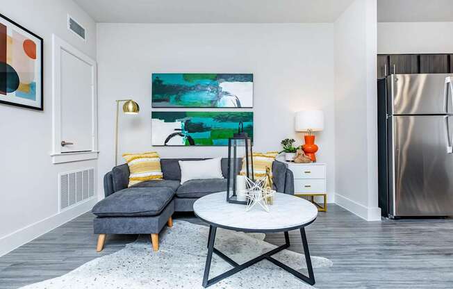 A modern living room with a grey sofa and a white coffee table.