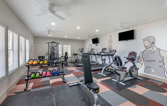 a home gym with exercise equipment and a wall mural of a man on the wall at Paisley and Pointe Apartments, Las Vegas, NV