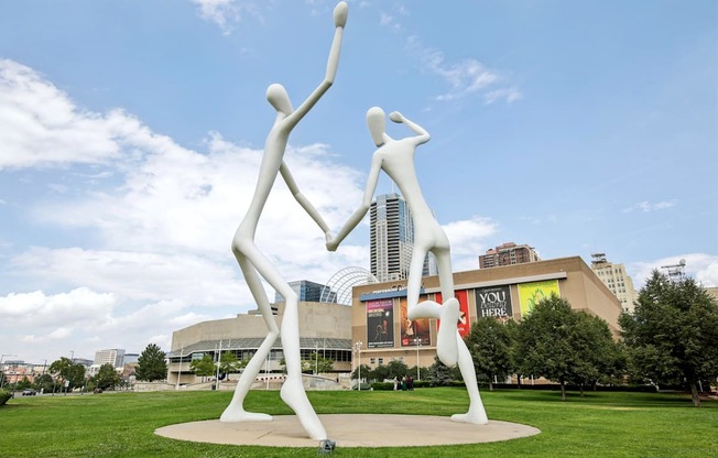 A white sculpture of two people dancing in front of a building.