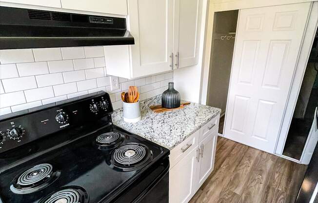 a kitchen with white cabinets and a black stove top oven