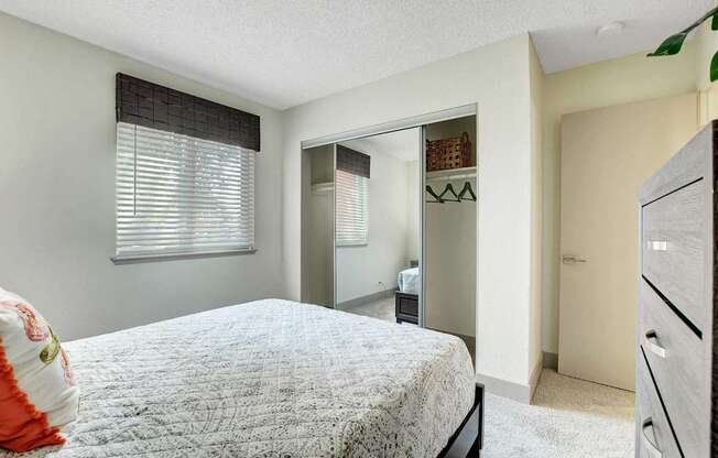 A bedroom with a bed, dresser, and mirror.