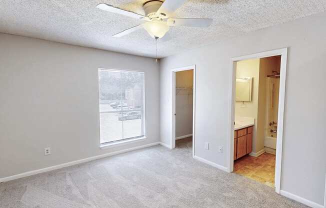 A room with a ceiling fan and a window.