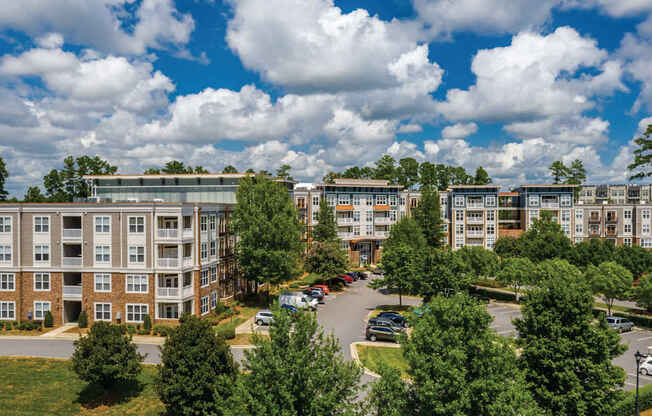 A large apartment complex with a parking lot in front.