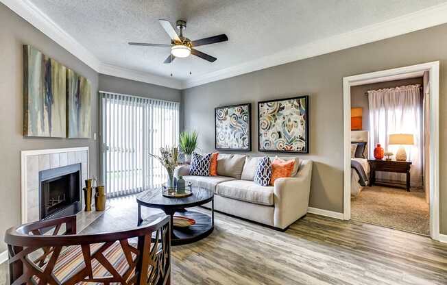 Model living room with stylish furnityre, laminate wood flooring, wood burning fireplace