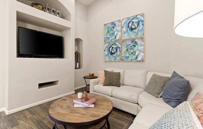 A living room with a white couch and a wooden coffee table.
