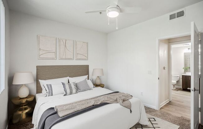 a bedroom with a large bed and a ceiling fan