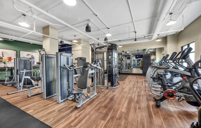A gym with a variety of equipment including treadmills, weights, and exercise machines.