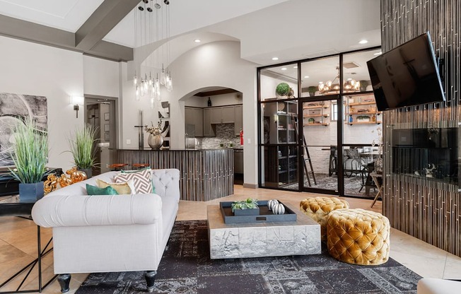 Resident lounge with fireplace, plush seating, coffee table, and adjacent glass-enclosed meeting room.