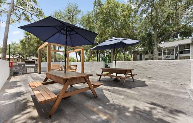 two picnic tables with umbrellas on a patio