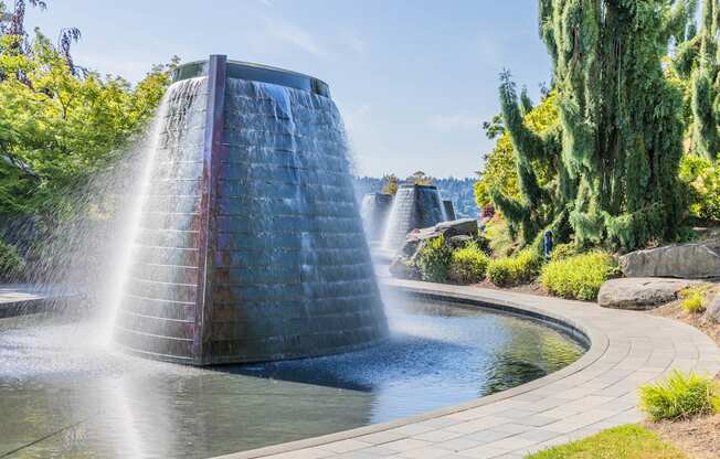 A water fountain in a garden with a clear blue sky at Spyglass Hill Apartments, Bremerton, 98337