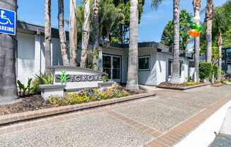 The entrance to the Grovet building with a sign and a parking sign.