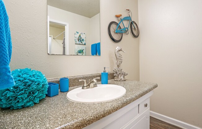 A bathroom with a blue towel and a mirror on the wall at The Drake in Bossier City, LA