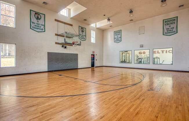 the inside of an empty gym with a wooden floor and a basketball court at Residences at Stevens Pond, MA 01906