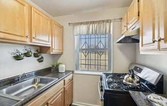 A kitchen with wooden cabinets and a black stove top oven.