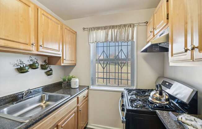 A kitchen with wooden cabinets and a black stove top oven.
