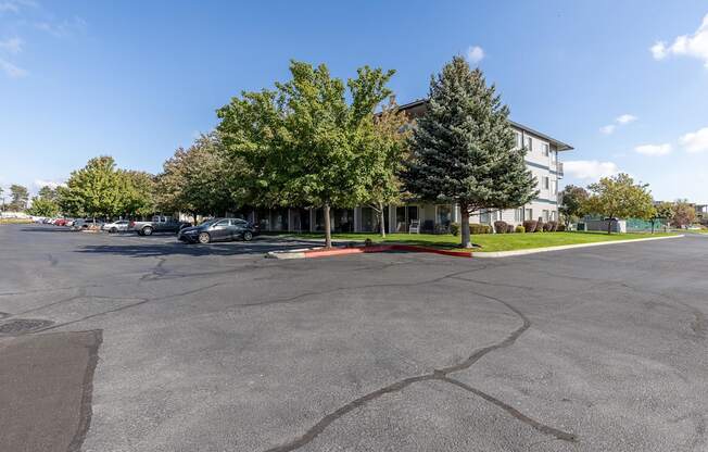 a parking lot in front of a building with trees  at Shoreline Village, Richland, Washington