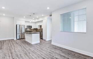 a kitchen with a stove top oven next to a refrigerator at The Vineyards Apartments, California