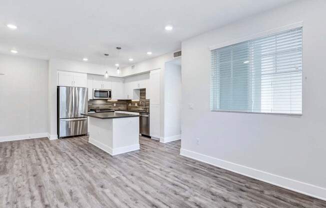 a kitchen with a stove top oven next to a refrigerator at The Vineyards Apartments, California