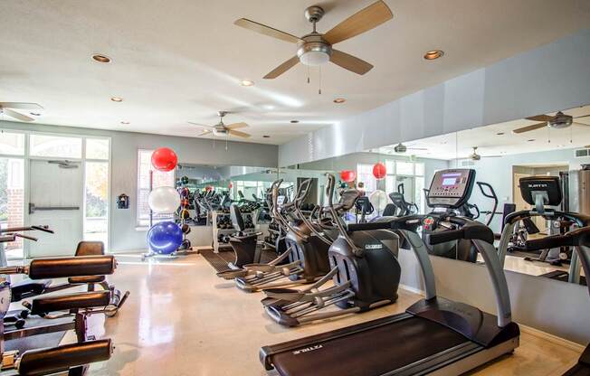 A gym with treadmills, elliptical machines, and other exercise equipment.