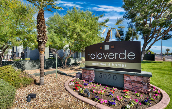 A sign for "tel averde apartment homes" is surrounded by flowers and trees.